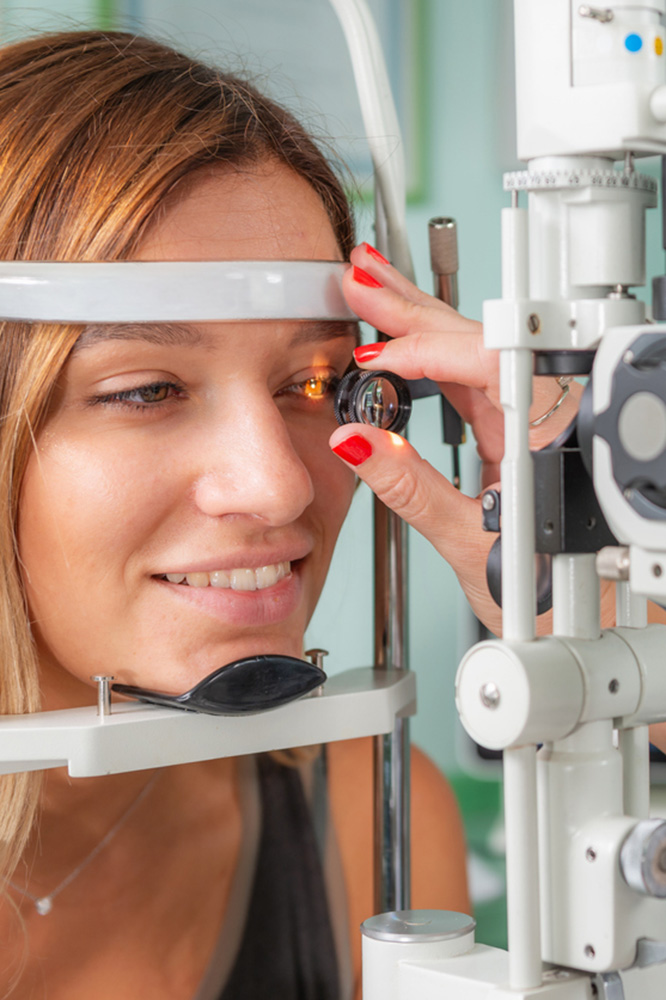 person on a slitlamp having an eye examination and being examined with a 90D lens