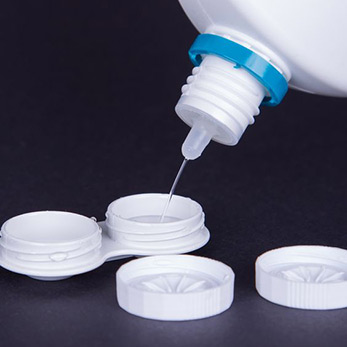 filling a contact lens case with contact lens disinfectant.